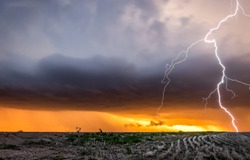 Lightning over a field in a thunderstorm. Thunderstorm lightning