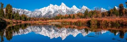 Snow peaks are reflected in the lake. Mountain lake panorama. Mountain lake panoramic landscape. Lake in mountains