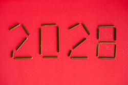 Numbers of year 2028 (twenty twenty eight) on red background made of green plant stem. Happy New Year eco environment conscious concept.