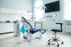 Dental equipment in dentist office in new modern stomatological clinic room. Background of dental chair and accessories used by dentists in blue, medic light. Copy space, text place
