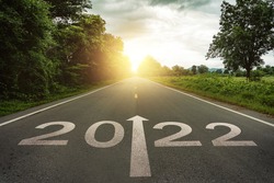 New year 2022 or straightforward concept. Text 2022 written on the road in the middle of asphalt road at sunset.Concept of planning and challenge, business strategy, opportunity ,hope, new life change