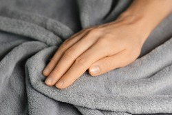 Grey blanket texture. Wave material pattern. Gentle and fluffy blanket. Woman touching grey blanket