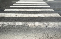pedestrian crossing of a street with worn and ruined asphalt.  Zebra crossing in a European city.  Road signs and pedestrian crossing.  Road safety