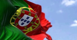 Detail of the national flag of Portugal waving in the wind on a clear day. Democracy and politics. European country. Selective focus