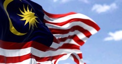 Detail of the national flag of Malaysia waving in the wind on a clear day. Democracy and politics. Patriotism. Selective focus. Southeastern Asian country.