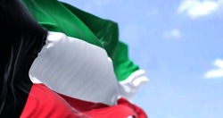 Detail of the national flag of Kuwait waving in the wind on a clear day. Kuwait is a country in Western Asia. Selective focus.