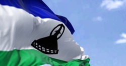Detail of the national flag of Lesotho waving in the wind on a clear day. Lesotho is an enclaved country surrounded entirely by South Africa. Selective focus.