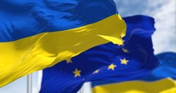 the national flag of Ukraine waving with blurred european union flag on a clear day. Democracy and politics.