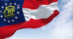 The state flag of Georgia waving in the wind. Georgia is a state in the Southeastern region of the United States. Democracy and independence.