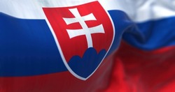 Close-up view of the Slovakia national flag waving in the wind. Slovakia is a landlocked country in Central Europe. Fabric textured background. Selective focus