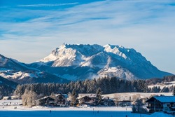 View to the Austrian mountain called Wilder Kaiser from german village Reit im Winkl on a sunny winter day, copy space