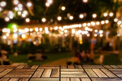 empty brown wooden floor or wooden terrace with abstract night light bokeh of night festival in garden, blurred background, copy space for display of product or object presentation, vintage color tone