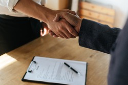 Partnership. two business people shaking hand after business signing contract in meeting room at company office, job interview, investor, success, negotiation, partnership, teamwork, financial concept