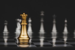 Leadership. gold queen with silver chess pieces on chess board game competition on dark background, chess battle, victory, success, management, team leader, teamwork and business strategy concept