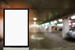 advertising billboard or blank showcase light box for your text message or media content with blurred image of intelligent car parking garage, commercial and marketing concept