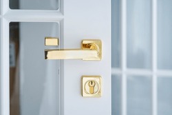 Elements of the interior of the apartment close-up. Detail of a white interior door with a doorknob and a latch. White door Golden handle. . High quality photo