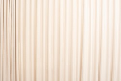 Cream-colored cloth, beige curtain fabric texture and background. 