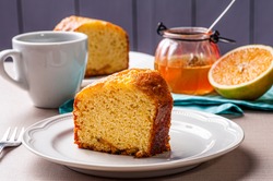 Homemade orange cake. Table with a piece of cake and cup of coffee.