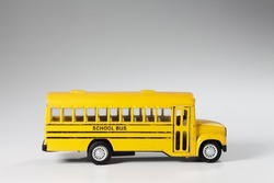 Toy model of yellow Bus over white background. Vintage generic transport toy. School bus