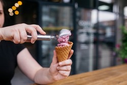 Ice cream cone. Ice cream with waffle cones. Waffle cone being held by a girl. Colorful cereal toppings for vibrance. perfect for hot summer days or winter.