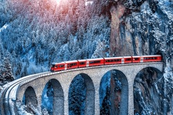 Aerial view of Train passing through famous mountain in Filisur, Switzerland.   train express in Swiss Alps snow winter scenery. 