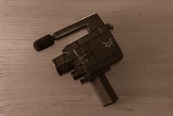 Vintage 8mm video camera on wooden background. Copy space. Selective focus.