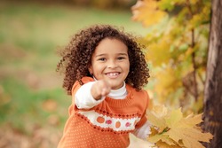 Portrait of cute adorable little  girl child making funny silly faces, showing tongue, in autumn fall park outside, playing having fun, lifestyle childhood
