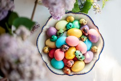 Colourful Easter eggs on white  background with lilac flowers