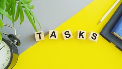 Tasks symbol. The concept word tasks on beautiful yellow, gray table background. Business and task or tasks concept
