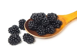 Wooden spoon with blackberries on a white background. Healthy and tasty berry