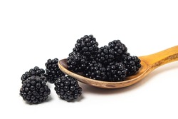 Wooden spoon with blackberries on a white background. Healthy and tasty berry