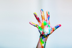 Colourful child's painted hand up on the white background