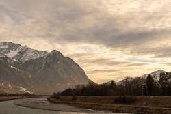 Vaduz, Liechtenstein, December 23, 2021 Late afternoon at the rhine river with clouds in the sky