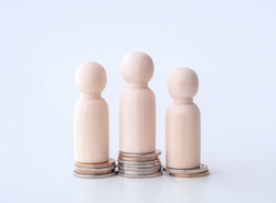 Miniature wooden figures of people standing on stack of coins. Inequality and social class. Income and economic inequality concept. Inequality in social class, ideology and health. Financial growth