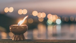 Soul and spirituality abstract concept  for mourning and world human spirit day with warm candle light bokeh illumination, golden sunset sky and reflective river wave background
