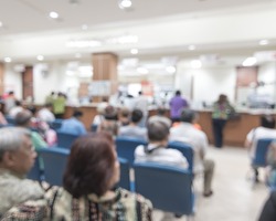 Blur medical background clinic service counter lobby with patient paying bill at cashier desk 