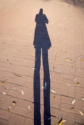 Female shadow on the asphalt. Shadow of man