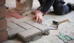 builder puts tiles in the yard. Paving slab. DIY home improvement.