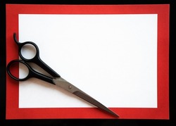 Hairdressing scissors in a red frame on a white background for text. Opening of a hairdressing salon. The announcement of a haircut.