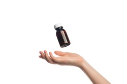 A jar of pills hovers or flying over a female hand, isolate