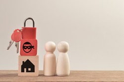 Wooden doll figures with padlock, scammer and home. Real estate scam concept.