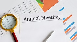 Paper with Annual Meeting on the table with pen