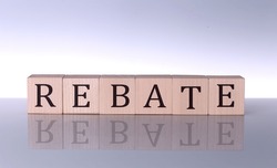 REBATE concept, wooden word block on grey background