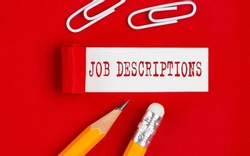 JOB DESCRIPTIONS message written under torn red paper with pencils and clips, business
