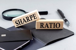 SHARPE RATIO text on a wooden block on black notebook , business concept