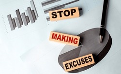 STOP MAKING EXCUSES text on a wooden block on chart background