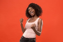 I won. Winning success happy woman celebrating being a winner. Dynamic image of caucasian female model on red studio background. Victory, delight concept. Human facial emotions concept. Trendy colors
