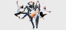 Happy office workers jumping and dancing in casual clothes or suit with folders on white. Ballet dancers. Business, start-up, working open-space, motion and action concept. Creative collage.