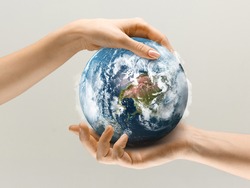 Hands holding planet Earth, close up. Environment save, taking care of nature and ecology, supporting hands concept. Globe woldwide protection, traveling and protecting of human's home.