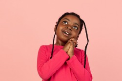 Dreaming. Handsome african little girl portrait isolated on pink studio background with copyspace. Stylish female model. Concept of human emotions, facial expression, sales, ad, fashion, youth.